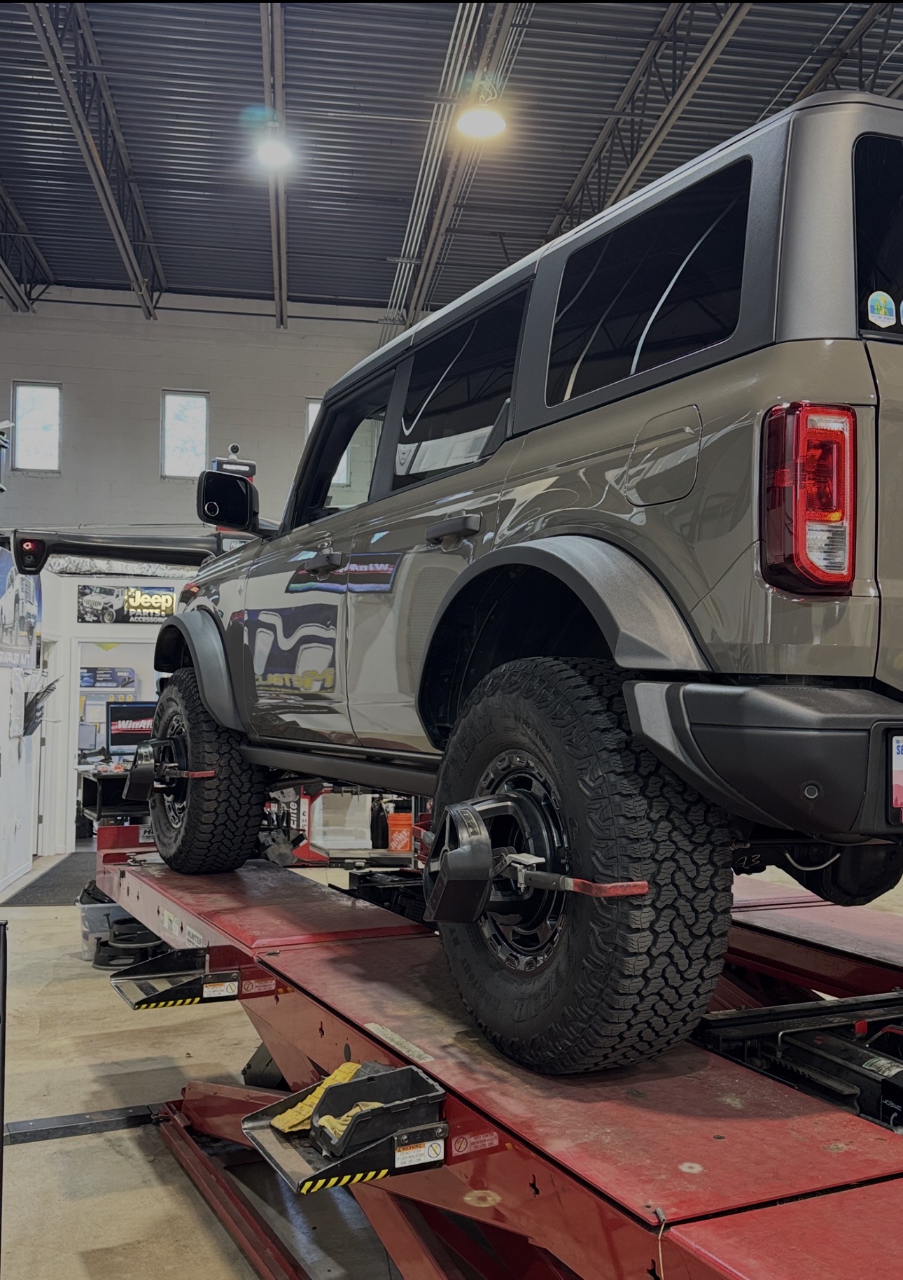 Brown-gray Ford Bronco on the alignment rack at Bull Run 4x4