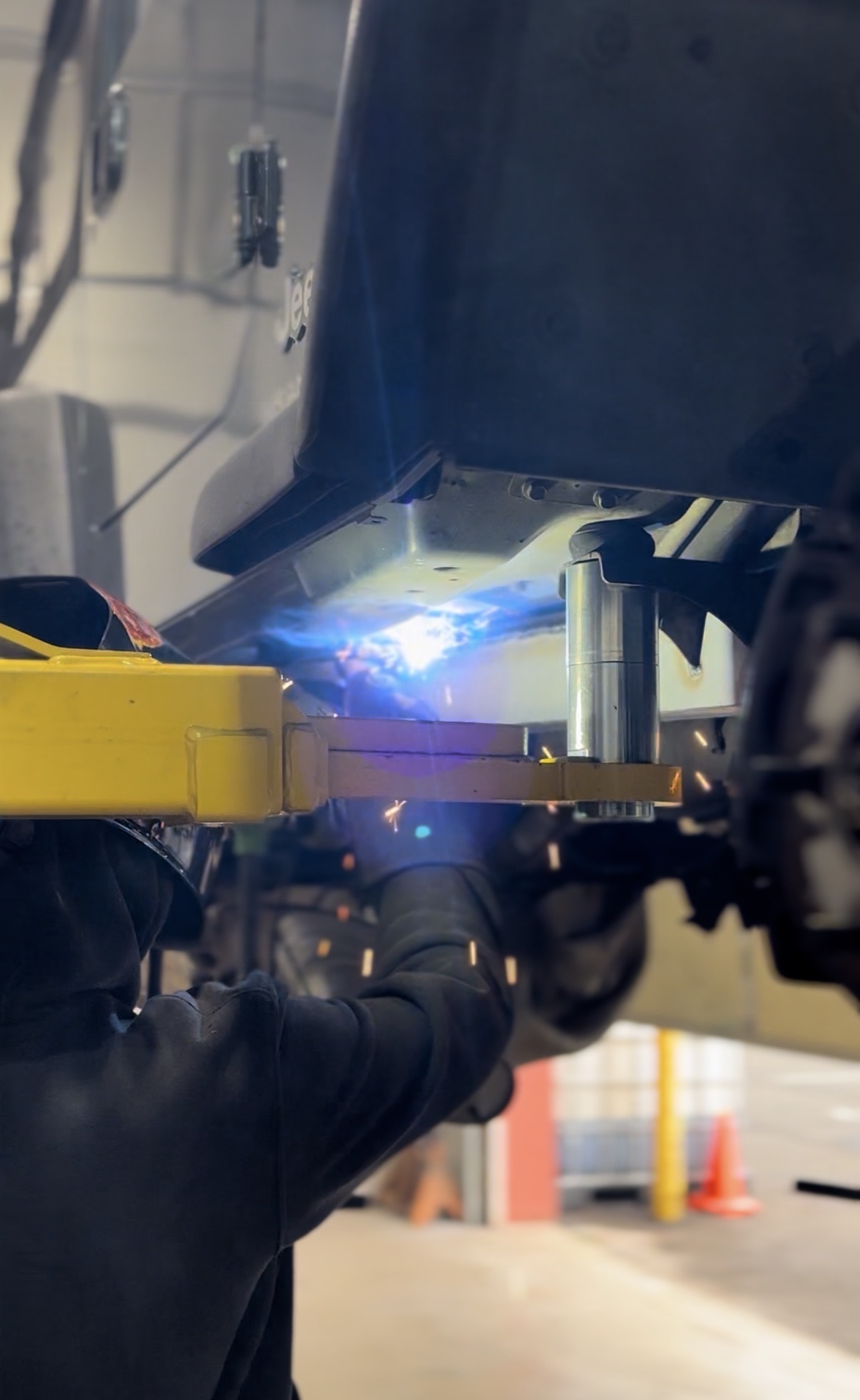 Technician welding a SafeT Cap frame repair section onto a Jeep at Bull Run 4x4